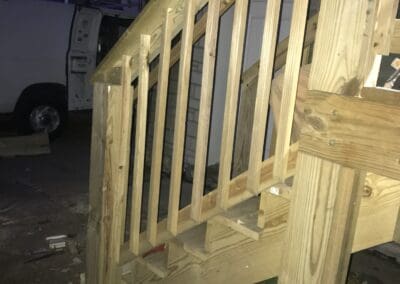 Close-up view of a newly constructed wooden deck railing and steps, showcasing sturdy craftsmanship and untreated wood materials, suitable for outdoor decks, walkways, and ramps designed for durability and accessibility.