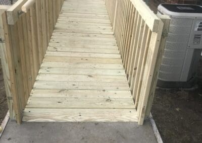 Wooden accessibility ramp with sturdy railings on both sides, designed for safe and comfortable outdoor use, showcasing quality craftsmanship suitable for decks, walkways, and ramps.