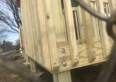 Close-up view of a newly constructed wooden deck railing made of treated lumber, showcasing expert craftsmanship and durable materials for outdoor decks, walkways, and ramps designed for beauty, comfort, and longevity.